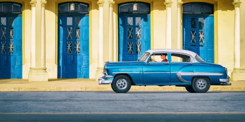 Voiture américaine ancienne bleue circulant dans les rues de La Habana Vieja, à Cuba