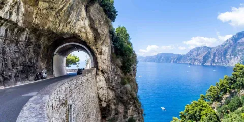 Route panoramique de la côte amalfitaine creusée dans la falaise au-dessus de la mer Méditerranée, l’un des plus beaux road trips en Italie.