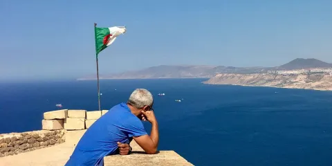Vue panoramique d'Alger depuis la Casbah avec le drapeau algérien, une image emblématique pour préparer un voyage en Algérie
