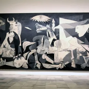 Visiteur observant le tableau Guernica de Picasso au musée Reina Sofía à Madrid