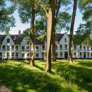 Béguinage de Bruges avec ses maisons blanches historiques entourant un jardin arboré classé au patrimoine mondial de l'UNESCO