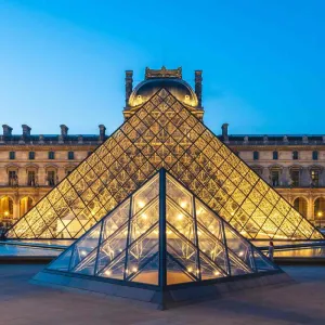 Pyramide de verre du musée du Louvre illuminée devant l'ancien palais royal à Paris