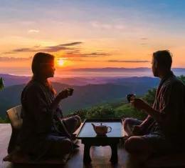 Voyageur logeant chez l’habitant en Asie, partageant un moment avec un résident local au coucher du soleil