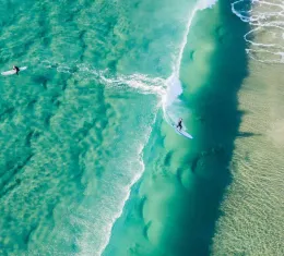 Surfeurs sur une plage australienne, illustrant les meilleurs spots de surf en Australie