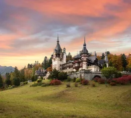 Panorama du château de Peleș en Transylvanie, Roumanie, célèbre château royal entouré de jardins, dans les Carpates au coucher du soleil