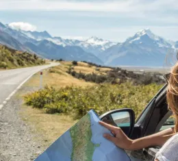 Femme regardant une carte dans une voiture lors d’un road trip sur l’île du Sud en Nouvelle-Zélande