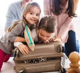 Famille avec deux enfants préparant les valises pour un voyage en famille