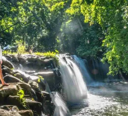 Cascade dans la forêt tropicale à l’île Maurice avec randonneuse