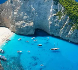 Baie de Navagio à Zakynthos en Grèce entourée de falaises calcaires et d’une mer bleu intense