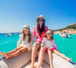 Une mère avec ses enfants en bateau dans les eaux turquoise de Sardaigne pendant les vacances