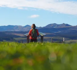 Randonneuse face aux volcans du massif du Sancy dans le Puy-de-Dôme, au cœur des paysages naturels d'Auvergne.
