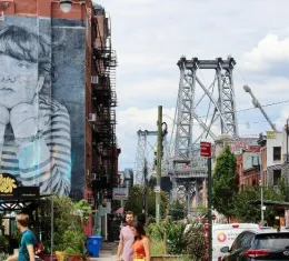 Rue animée de Williamsburg à Brooklyn avec le pont de Williamsburg et une fresque de street art en arrière-plan