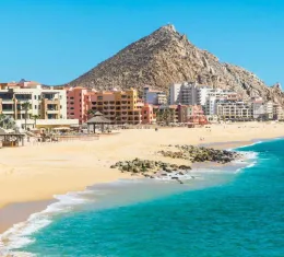 Vue de la plage El Médano à Los Cabos en Basse-Californie, avec les hôtels en bord de mer et les montagnes désertiques