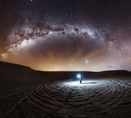 Voyageur sous la Voie lactée dans un paysage désertique