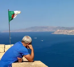 Vue panoramique d'Alger depuis la Casbah avec le drapeau algérien, une image emblématique pour préparer un voyage en Algérie