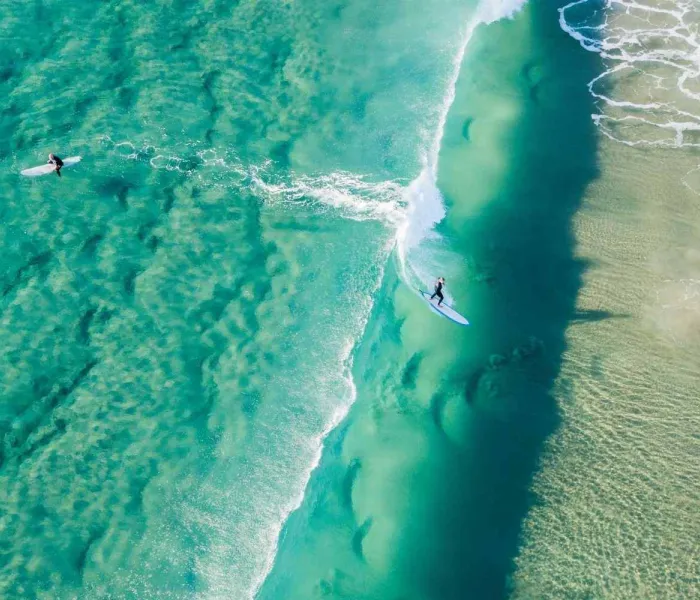 Surfeurs sur une plage australienne, illustrant les meilleurs spots de surf en Australie