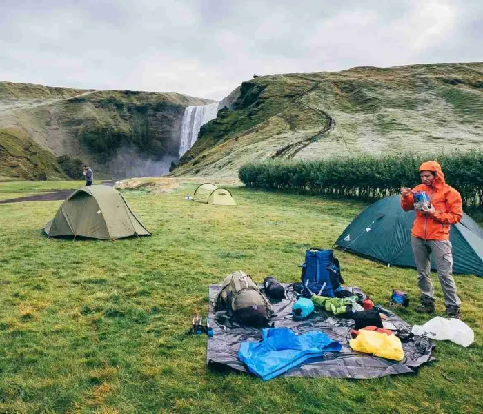 Voyageuse prenant son petit-déjeuner devant sa tente avant une randonnée entre Skógar et Þórsmörk en Islande