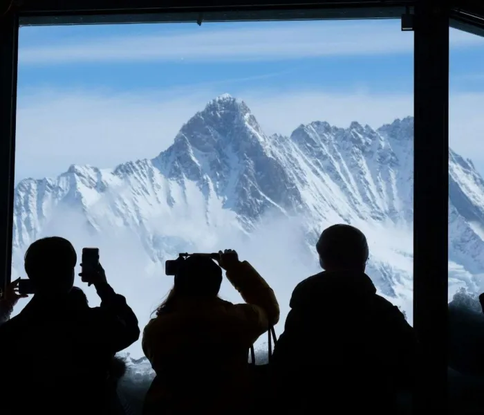 Touristes admirant les sommets enneigés depuis le Jungfraujoch dans les Alpes suisses