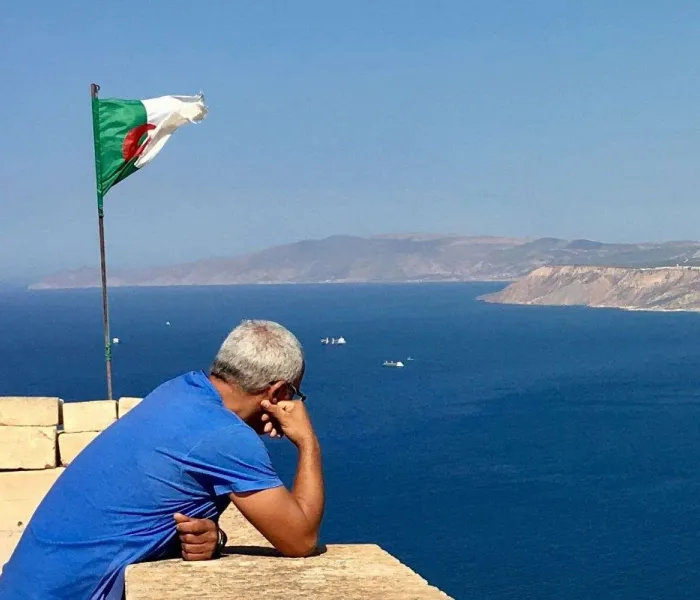 Vue panoramique d'Alger depuis la Casbah avec le drapeau algérien, une image emblématique pour préparer un voyage en Algérie