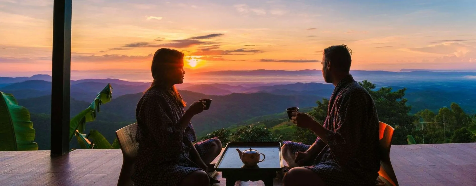 Voyageur logeant chez l’habitant en Asie, partageant un moment avec un résident local au coucher du soleil