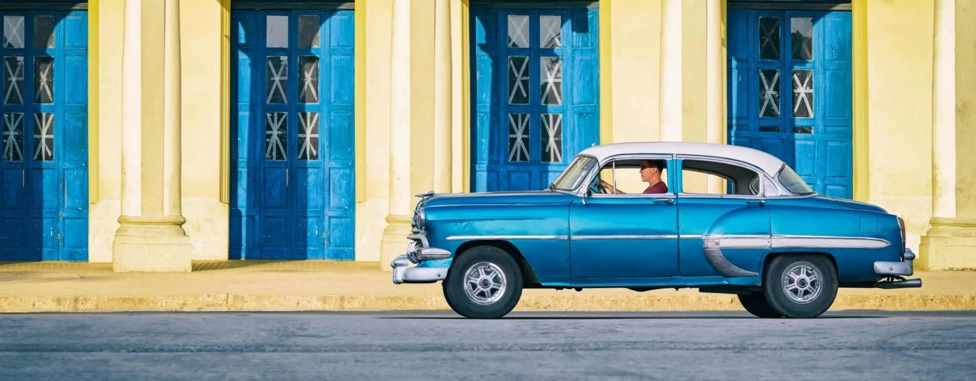 Voiture américaine ancienne bleue circulant dans les rues de La Habana Vieja, à Cuba