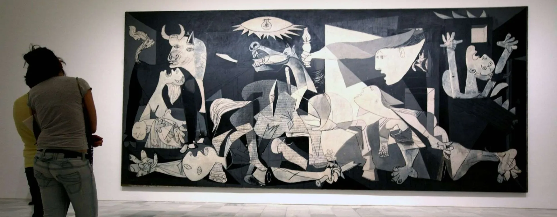 Visiteur observant le tableau Guernica de Picasso au musée Reina Sofía à Madrid