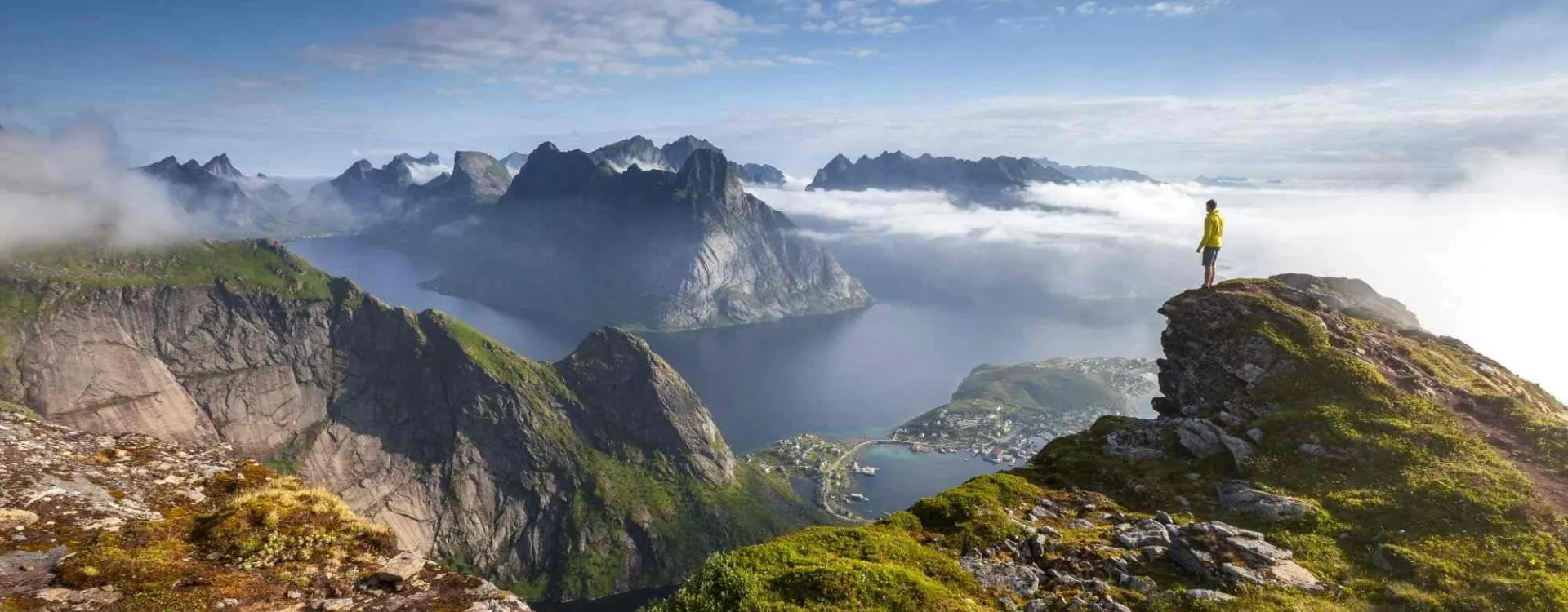 Randonneur sur un promontoire rocheux au lever du soleil dans les îles Lofoten en Norvège