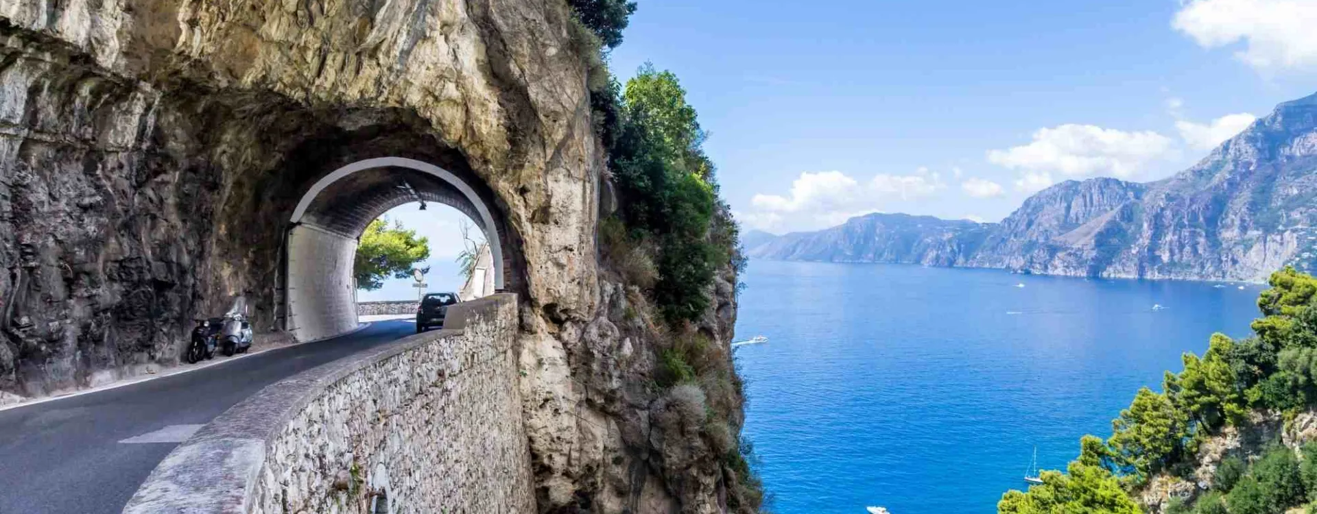 Route panoramique de la côte amalfitaine creusée dans la falaise au-dessus de la mer Méditerranée, l’un des plus beaux road trips en Italie.