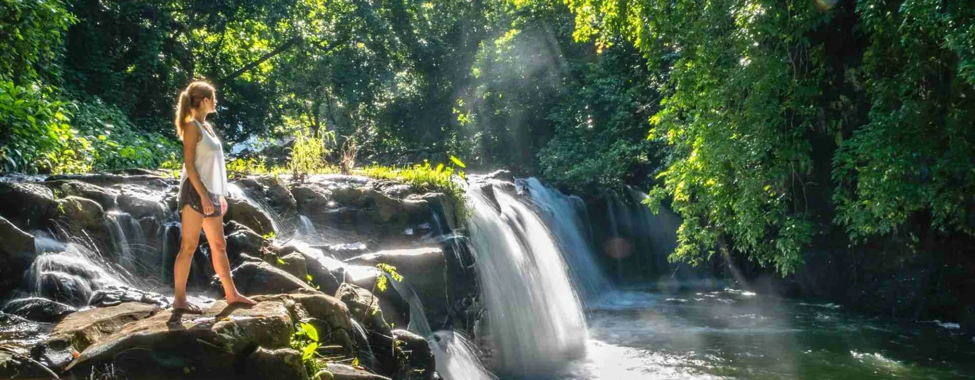 Cascade dans la forêt tropicale à l’île Maurice avec randonneuse
