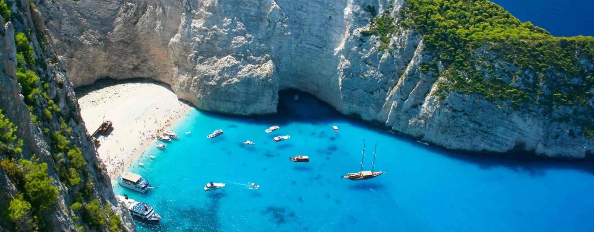 Baie de Navagio à Zakynthos en Grèce entourée de falaises calcaires et d’une mer bleu intense