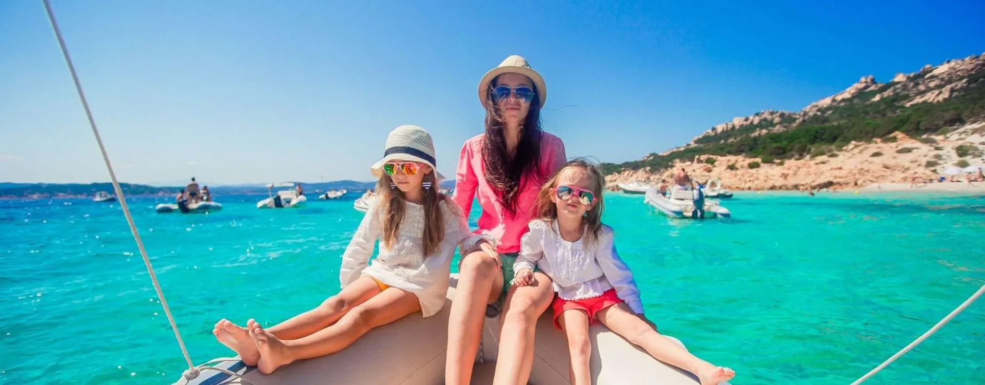 Une mère avec ses enfants en bateau dans les eaux turquoise de Sardaigne pendant les vacances