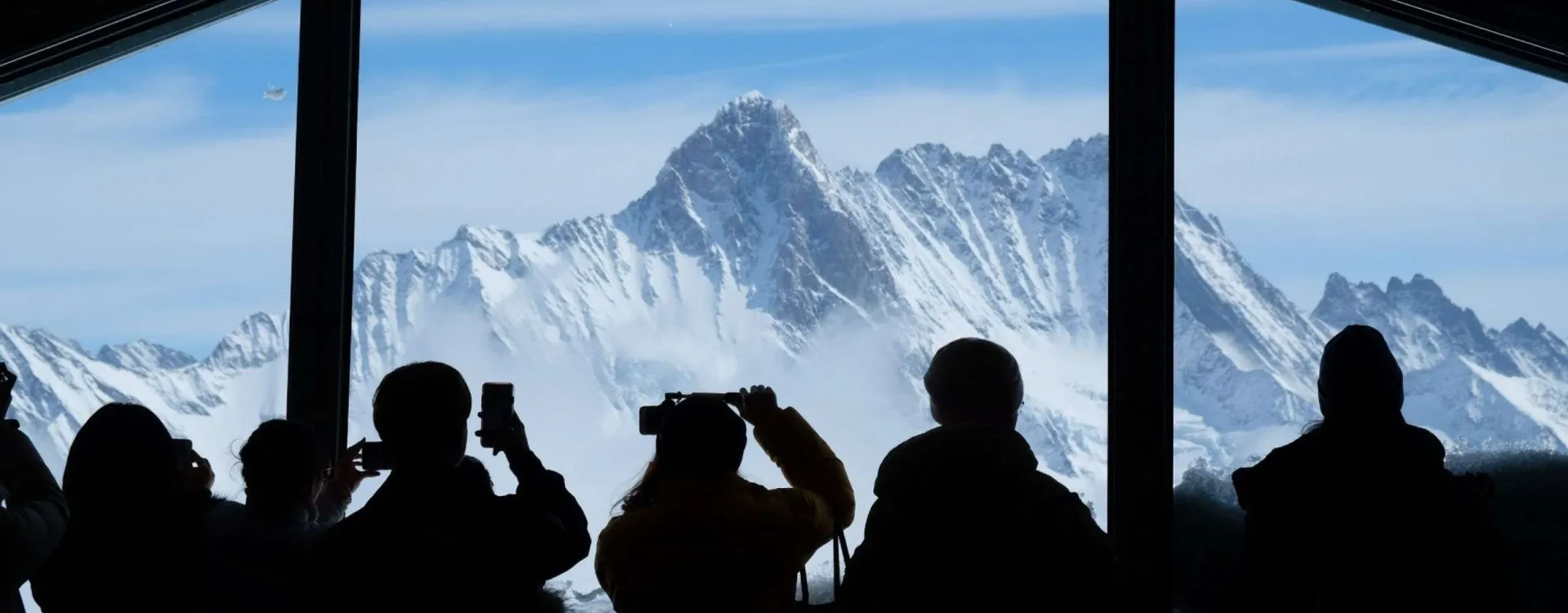 Touristes admirant les sommets enneigés depuis le Jungfraujoch dans les Alpes suisses