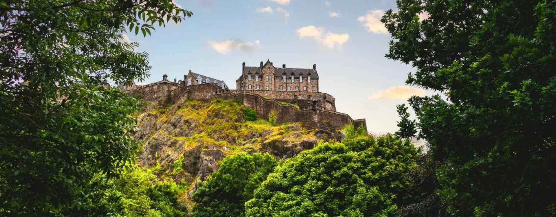 Le château d'Édimbourg dominant Castle Rock au coucher du soleil, vu depuis Princes Street Gardens, en Écosse.