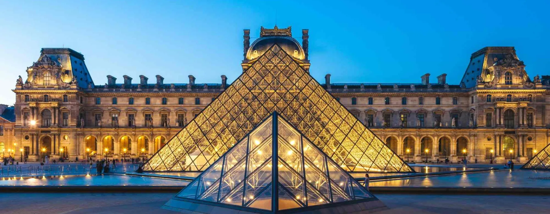 Pyramide de verre du musée du Louvre illuminée devant l'ancien palais royal à Paris