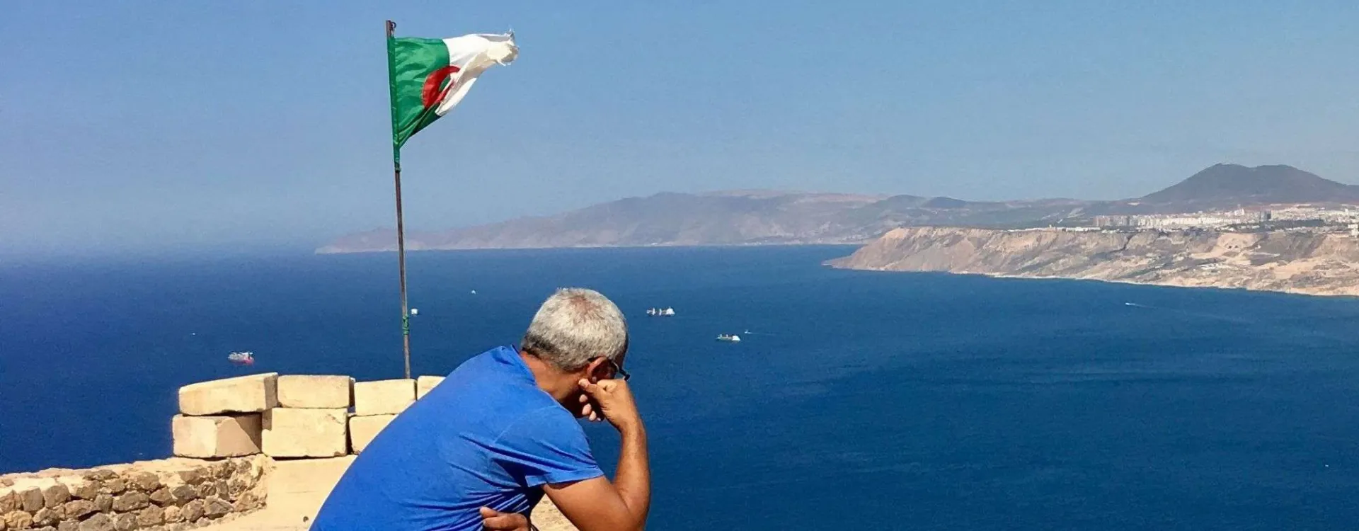 Vue panoramique d'Alger depuis la Casbah avec le drapeau algérien, une image emblématique pour préparer un voyage en Algérie