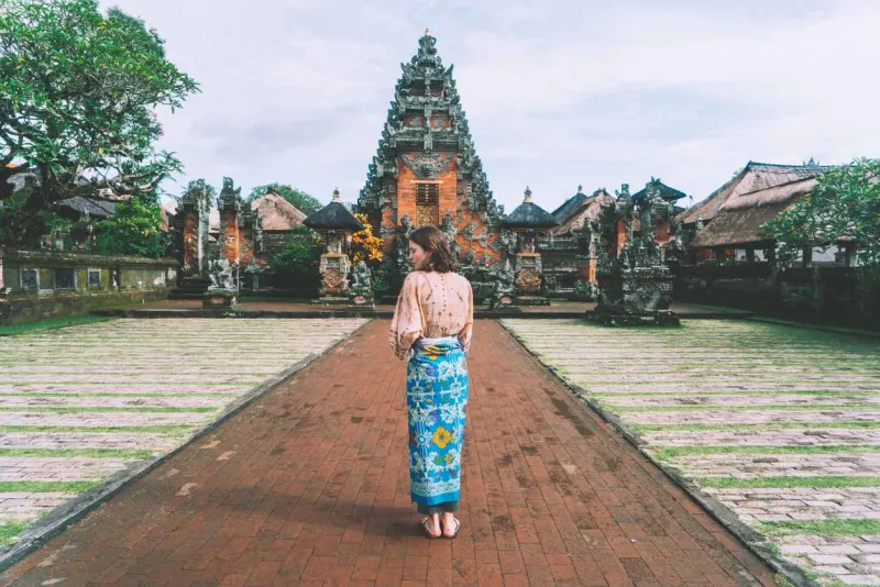 Femme entrant dans un temple à Bali en Indonésie