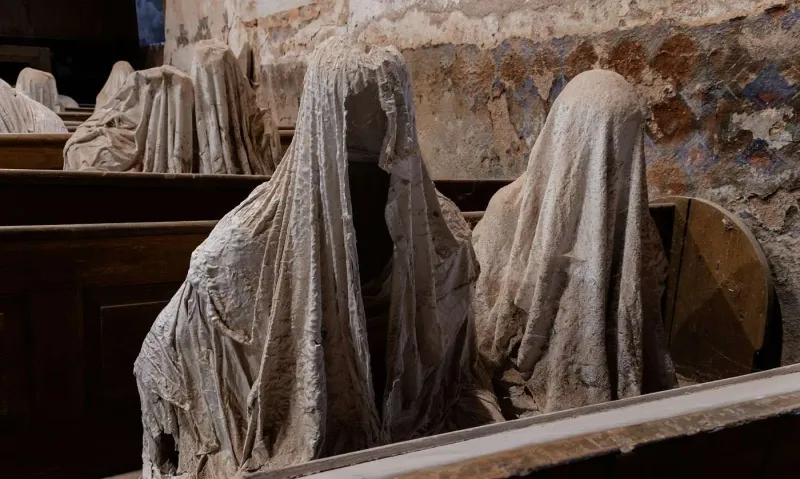 Dans l’église abandonnée de Luková, des silhouettes fantomatiques en plâtre semblent prier dans le silence.