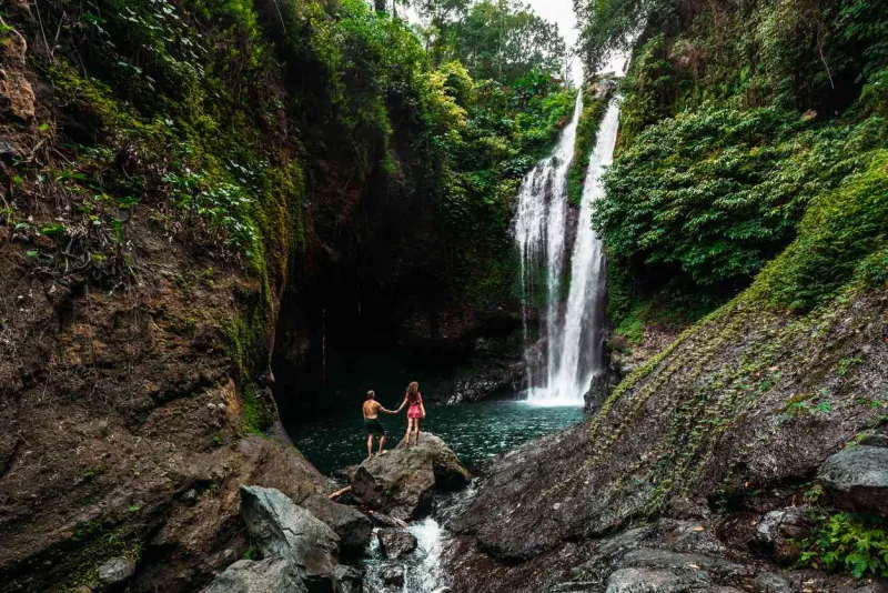 Un couple admire une cascade à Bali.