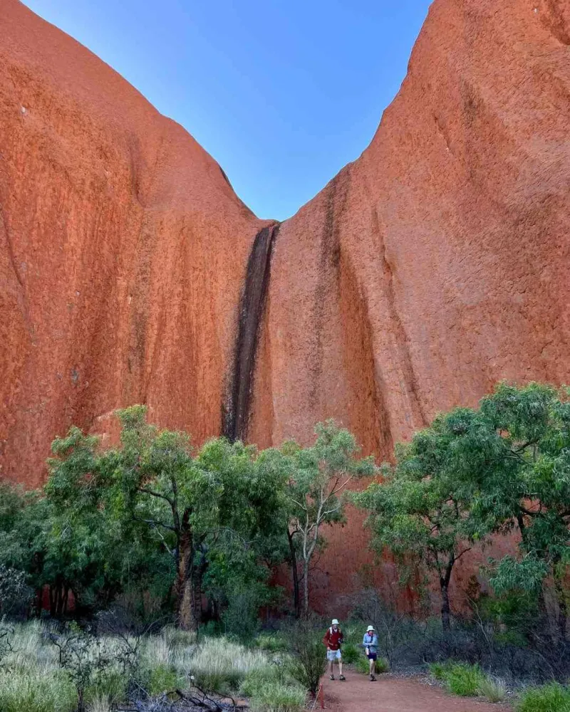Les sentiers de randonnée permettent de découvrir le monolithe au plus près, entre grottes, art rupestre et paysages désertiques.