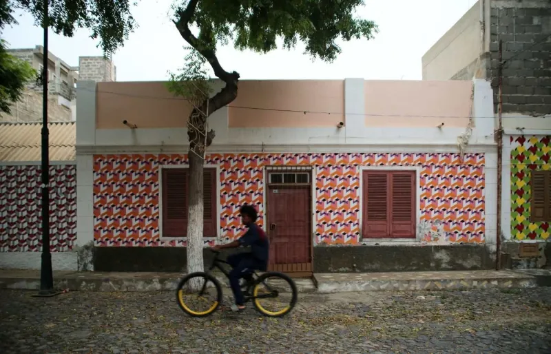 Un homme à vélo devant des façades colorées à Sal Rei, sur l’île de Boa Vista