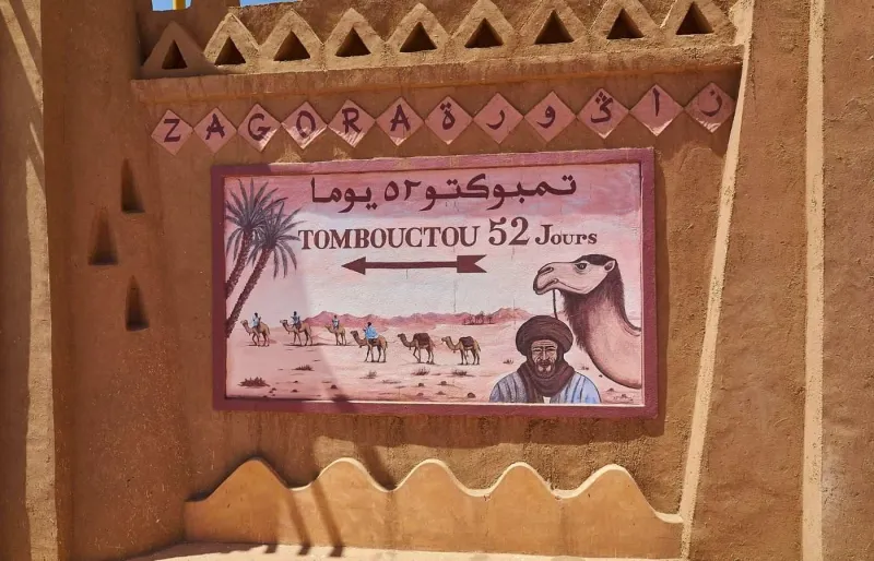 Panneau indiquant Tombouctou à 52 jours de route dans le désert