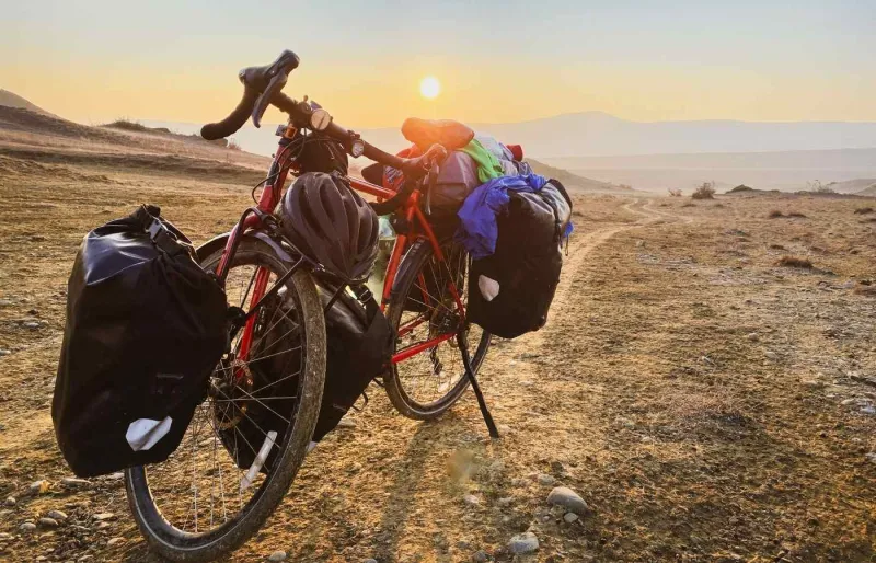 Vélo de voyage rouge chargé de sacoches dans le parc national de Vashlovani