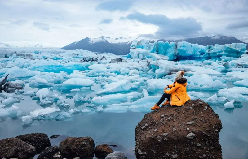 Femme au bord du lagon glaciaire de Jökulsárlón, dans le sud de l’Islande