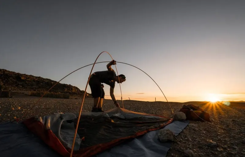 Montage d’une tente de camping lors d’un bivouac en milieu isolé