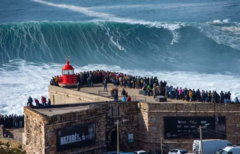 Vagues géantes de Nazaré devant le phare, sur la côte atlantique du Portugal