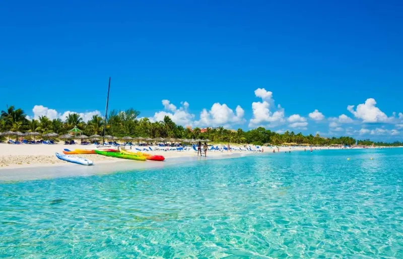 Plage de Varadero à Cuba avec bateaux colorés et parasols en paille sur le sable blanc
