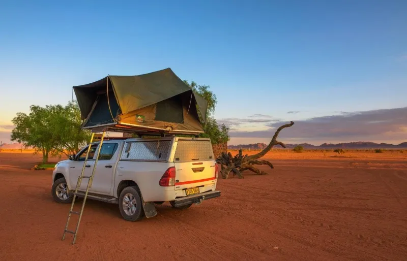 Tente de toit installée sur un 4x4 dans un campement du désert en Namibie, symbole d’un safari en autonomie