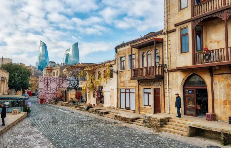 Vue sur la vieille ville de Bakou et les Flame Towers en arrière-plan, illustrant le contraste entre patrimoine historique et urbanisation moderne
