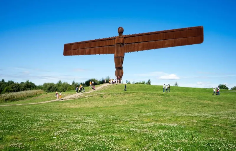 Visiteurs devant la sculpture monumentale Angel of the North à Gateshead en Angleterre