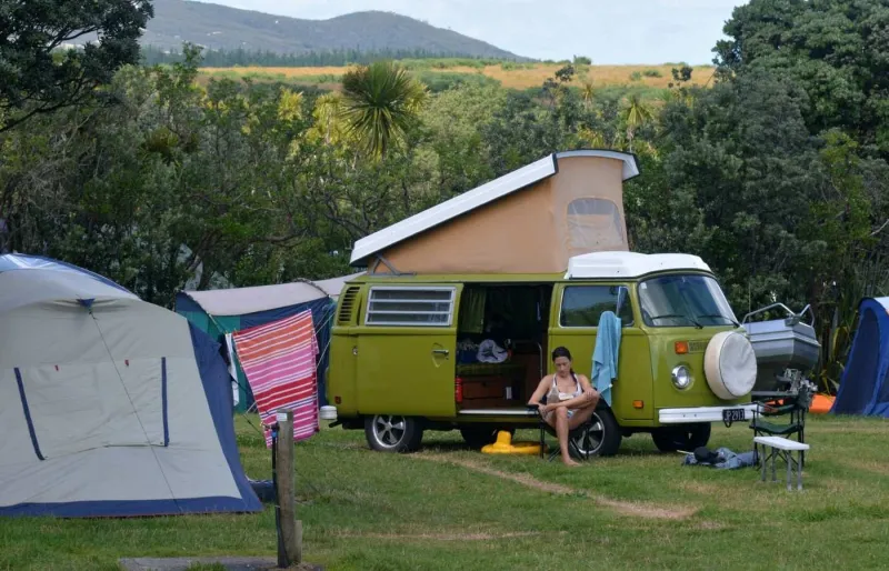 Jeune femme en road trip se relaxant dans un camping à Maitai Bay en Nouvelle-Zélande